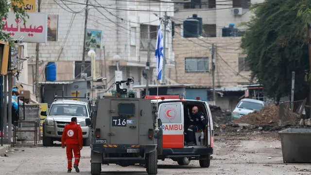 epa11844197 Israeli forces check a Palestinian ambulance as they block a road on the second day of an Israeli military operation in the West Bank city of Jenin, 22 January 2025. The Israeli military launched a 'counterterrorism operation' in Jenin on 21 January 2025, resulting in at least 10 Palestinian deaths and more than 50 injuries, according to the Palestinian Ministry of Health. EPA/ALAA BADARNEH