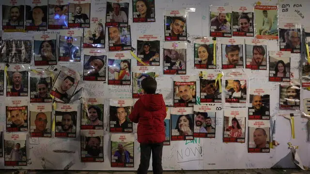 epa11124313 A boy looks at pictures of hostages as protesters take part in a rally calling for the immediate release of Israeli hostages held by Hamas in Gaza, outside the Kirya military base in Tel Aviv, Israel, 03 February 2024. According to the Israeli army, 136 Israelis were still held hostage by Hamas inside the Gaza Strip since 07 October 2023. EPA/ABIR SULTAN