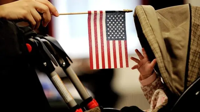 epa07133212 (FILE) - A baby reaches for an American flag held by her mother during naturalization ceremony at a federal building in New York, New York, USA, 14 January 2011 (reissued 31 October 2018). According to reports, US President Donald J. Trump plans to end birthright citizenship. EPA/JUSTIN LANE *** Local Caption *** 02529333