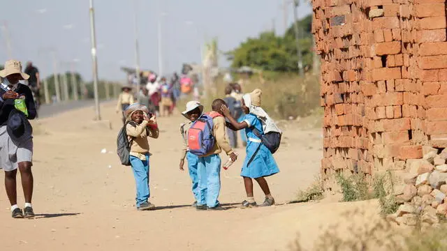 epa10016352 Children walk from school in Epworth just outside the capital Harare, Zimbabwe, 16 June 2022 on the Day of The African Child, which is marked annually on 16 June to recognize those who lost their lives in South Africa's Soweto Uprising on 16 June 1971, and the ongoing need to improve children education in Africa. EPA/AARON UFUMELI