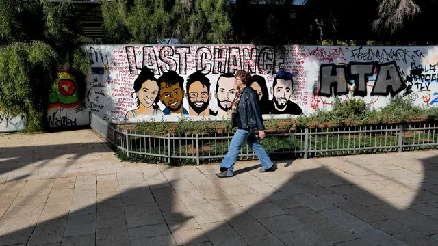 epa11842331 A woman walks past a mural calling for the release of Israeli hostages held by Hamas in Gaza, in Tel Aviv, Israel, 21 January 2025. According to Israel's military, around 94 Israeli hostages remain in captivity in the Gaza Strip, including the bodies of 33 confirmed dead. Israel and the Palestinian militant group Hamas implemented the first phase of a hostage release and Gaza ceasefire deal on 19 January 2025. EPA/ABIR SULTAN