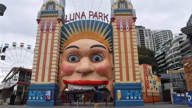 epa09334916 A pedestrian walks past the Luna Park in Sydney, New South Wales, Australia, 10 July 2021. Tough new restrictions are now in place for Greater Sydney after another spike in COVID-19 cases. EPA/MICK TSIKAS AUSTRALIA AND NEW ZEALAND OUT