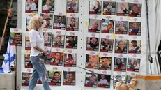 epa11830525 A woman with a dog walks past a display of posters calling for the release of Israeli hostages, who were abducted by militants during the 07 October 2023 Hamas attacks, outside the Kirya military headquarters in Tel Aviv, Israel, 17 January 2025. Israel and Hamas have agreed on a hostage release deal and a Gaza ceasefire to be implemented in the coming days following months of war. Israel's security cabinet is expected to meet on 17 January to approve the agreement. EPA/ABIR SULTAN