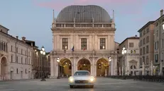 Una suggestiva immagine di un'auto storica in piazza Loggia - © www.giornaledibrescia.it