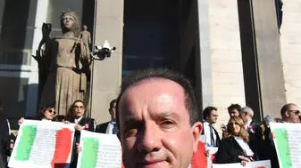 Magistrati sulla scalinata d'ingresso del Palazzo di Giustizia in toga, con una coccarda tricolore e manifesti con frasi a difesa della Costituzione, in segno di protesta, nel giorno della cerimonia dell'inaugurazione dell'Anno giudiziario nel Distretto, contro il disegno di legge sulla separazione delle carriere, Catania, 25 gennaio 2025. ANSA/ ORIETTA SCARDINO