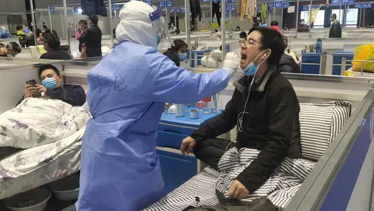 epa09895759 Nurses take swab samples of people for nucleic acid test in a temporary hospital for Covid-positive people in Shanghai, China, 18 April 2022. On 18 April 2022, there were 3 deaths reported in Shanghai city, 2.417 new locally transmitted COVID-19 cases and 19.831 local asymptomatic infections, and new local fatalities, according to the Shanghai Health Commission. The deaths were unvaccinated people aged between 89 and 91. On 1 April 2022, the city went into the general lockdown for 4 days. Those 4 days turned into 18 days and counting. Some of the residential buildings got released. However, the majority is still locked. Most delivery services are blocked off, leading people to fight against hunger with lack of possibility to buy groceries, and get medical care for non-Covid related diseases. EPA/SHAN SHI CHINA OUT