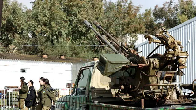 epa11799932 Israeli soldiers walk next to military weapons displayed for the media at Amiad military camp, northern Israel, 31 December 2024. According to the Israeli army, the equipment and weapons were uncovered throughout the ground operation in south Lebanon. A 60-day ceasefire agreement between Israel and Hezbollah came into force on 27 November 2024. EPA/ATEF SAFADI