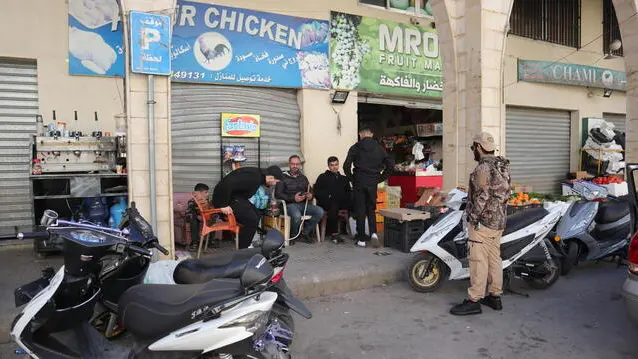 epa11838442 People sit next to a shop in Bint Jbeil after Lebanese authorities permitted the return of citizens who fled the city during the hostilities between Israel and Hezbollah, Bint Jbeil, southern Lebanon, 20 January 2025. A committee overseeing the ceasefire between Israel and Hezbollah declared Bint Jbeil and the town of Ainatha as 'safe areas' after the Lebanese army completed its deployment and allowed residents to return to their home villages. EPA/STR