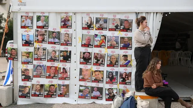 epa11830542 People stand near a display of posters calling for the release of Israeli hostages, who were abducted by militants during the 07 October 2023 Hamas attacks, outside the Kirya military headquarters in Tel Aviv, Israel, 17 January 2025. Israel and Hamas have agreed on a hostage release deal and a Gaza ceasefire to be implemented in the coming days following months of war. Israel's security cabinet is expected to meet on 17 January to approve the agreement. EPA/ABIR SULTAN