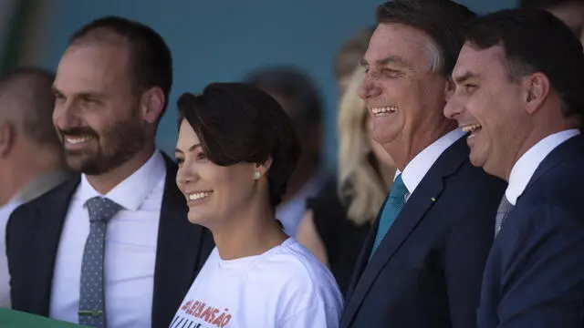 epa09815585 The President of Brazil, Jair Bolsonaro, his wife Michelle, and his sons Eduardo (L) and Flavio (R) take part in the reception of Brazilian and other citizens who resided in Ukraine and were rescued in Operation Repatriation, at the Military Air Base of Brasilia, Brazil, 10 March 2022. The President of Brazil, Jair Bolsonaro, received this 10 March a group of 68 people who lived in Ukraine and managed to escape the war and reach Poland, where they were picked up this week by two planes of the Brazilian Air Force (FAB). They are 42 Brazilians, 20 Ukrainians, five Argentines and one Colombian, along with eight dogs and two cats. EPA/JoÃ©dson Alves