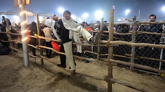 epa11859521 Devotees jump over barriers following a stampede accident during the Kumbh Mela festival near Sangam Ghat Prayagraj, Uttar Pradesh, India, 29 January 2025. A stampede took place during the Kumbh Mela religious festival in India's Sangam Ghat Prayagraj worship site after barriers broke under the pressure of massive crowds, with many causalities reported onsite without official confirmation given by local authorities. EPA/PRABHAT KUMAR VERMA