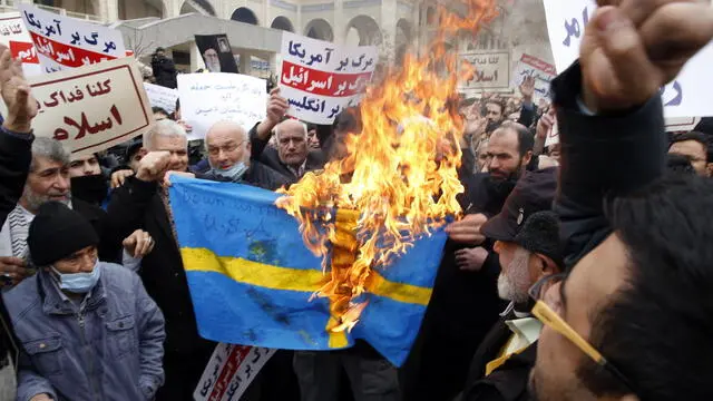 epaselect epa10433491 Iranians burn Sweden's flag during an anti-Sweden rally after the Friday prayer ceremony in Tehran, Iran, 27 January 2023. Iran harshly condemned the burning of the Koran in Sweden by the Leader of the far-right Danish political party Stram Kurs, Rasmus Paludan, in front of the Turkish embassy in Stockholm on 21 January 2023. EPA/ABEDIN TAHERKENAREH