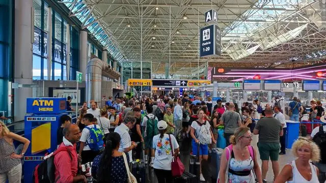 Terminal pieni di turisti in partenza per le vacanze all'aeroporto di Fiumicino in una foto d'archivio. ANSA/TELENEWS (generica, simbolica, turismo, turista, turisti, viaggio, vacanze, estate, aeroporto, voli, aerei)