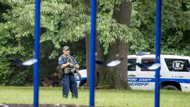 epa07034987 A Harford County Sheriff's deputy secures a perimeter in a playground on Mayberry Road, as police search for a gunman who fled the scene of a shooting at a Rite Aid Distribution Center in Aberdeen, Maryland, USA, 20 September 2018. Media reports indicate numerous casualties in the shooting. EPA/SCOTT SERIO