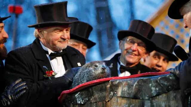 epa08187807 Groundhog club inner circle members look on as Punxsutawney Phil makes his prediction during the Groundhog Day celebration at Gobblers Knob in Punxsutawney, Pennsylvania, USA, 02 February, 2020. Punxsutawney Phil, the weather predicting groundhog, did not see his shadow and predicted an early spring. EPA/DAVID MAXWELL