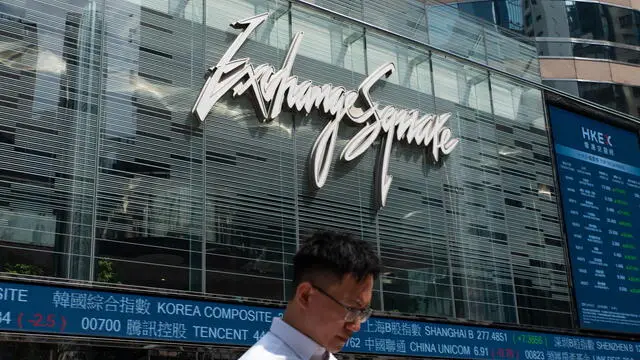 epa11648618 A man walks past screens at the Exchange Square, the building housing the stock market, in Hong Kong, China, 08 October 2024. Hong Kong's Hang Seng Index on 08 October plunged by over 9 percent to close at 20,926.79, its worst result since 2008. EPA/BERTHA WANG