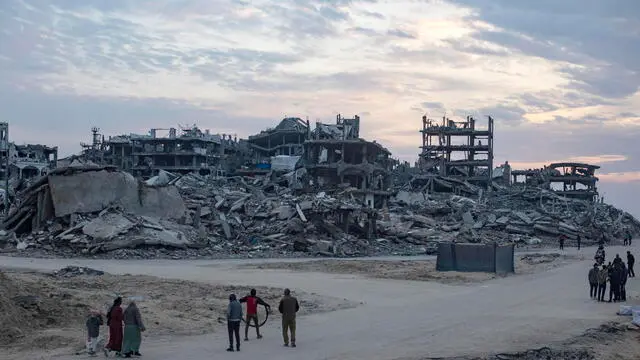 epa11873359 Palestinians walk through a street among the rubble of destroyed buildings in Gaza City, 03 February 2025. Israel and Hamas implemented the first phase of a hostage release and ceasefire deal on 19 January 2025. More than 46,000 Palestinians have been killed in the Gaza Strip, according to the Palestinian Ministry of Health, since Israel launched a military campaign in the strip in response to a cross-border attack led by the Palestinian militant group Hamas on 07 October 2023, in which about 1,200 Israelis were killed and more than 250 taken hostage. EPA/HAITHAM IMAD