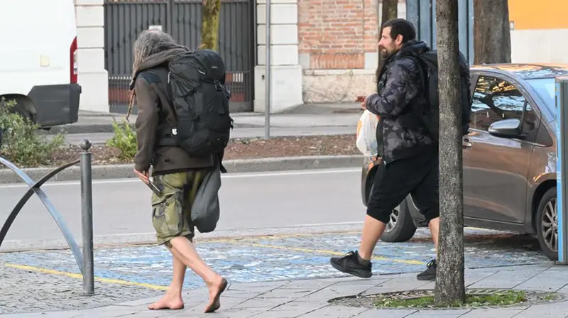 Un uomo scalzo all'uscita della stazione - Foto Gabriele Strada/Neg © www.giornaledibrescia.it