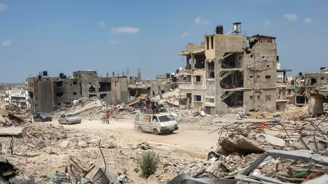 epa11314723 Palestinians drive past destroyed buildings in Khan Yunis after the Israeli army withdrew its forces from the southern Gaza Strip, 02 May 2024. More than 34,550 Palestinians and over 1,455 Israelis have been killed, according to the Palestinian Health Ministry and the Israel Defense Forces (IDF), since Hamas militants launched an attack against Israel from the Gaza Strip on 07 October 2023, and the Israeli operations in Gaza and the West Bank which followed it. EPA/HAITHAM IMAD