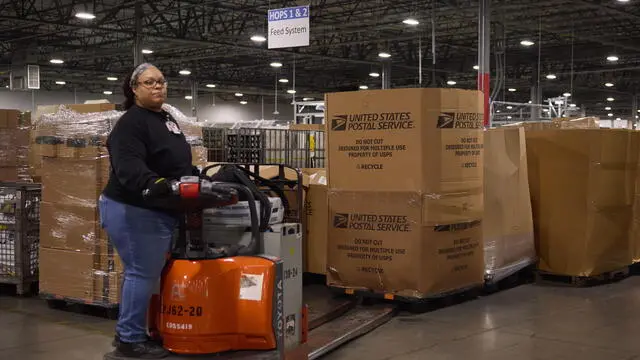 epa11005021 A postal employee moves boxes filled with mail at the US Postal Service, Los Angeles Processing and Distribution Center in Los Angeles, California, USA, 30 November 2023. The processing and distribution center in Los Angeles is the largest in the United States and sorts upwards of 1 million pieces of mail. During the 2023 holiday season the postal service is expecting to process around 30 million pieces of mail at this facility. EPA/ALLISON DINNER