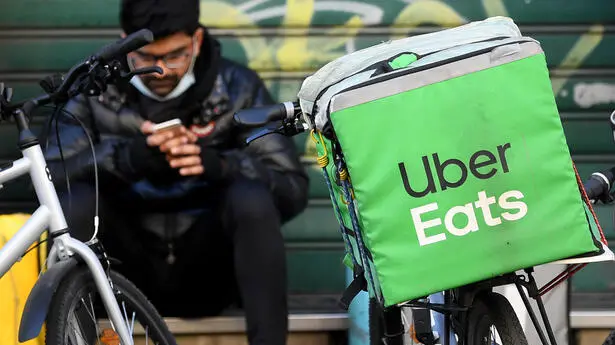 Un rider di Uber controlla il suo smartphone, Milano, 24 febbraio 2021.La Procura di Milano ha aperto un'indagine "fiscale" su Uber Eats, filiale italiana del colosso americano già finita in amministrazione giudiziaria per caporalato sui rider, "per verificare se sia configurabile una stabile organizzazione occulta" dal punto di vista fiscale. Lo ha annunciato il procuratore di Milano Francesco Greco nel corso di una conferenza stampa convocata per fare il punto sulle indagini a tutela dei ciclofattorini avviate nel capoluogo lombardo.ANSA/DANIEL DAL ZENNARO