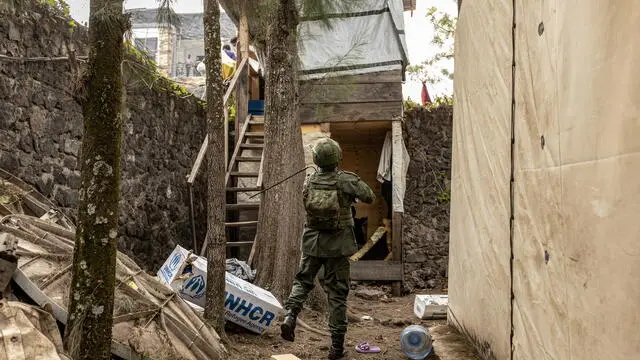 epa11861256 A member of the M23 armed group chases away looters from a UNHCR facility in Goma, Democratic Republic of the Congo, 29 January 2025. M23, supported by Rwanda, have tightened their grip on Goma, the capital city of North Kivu in the eastern Democratic Republic of the Congo. EPA/MOISE NIYONZIMA