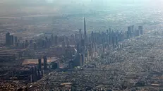 epa11850501 An aerial view taken from behind airplane's window glass shows the world's tallest building of Burj Khalifa (C) and Dubai's skyscrapers in Dubai, United Arab Emirates, 24 January 2025. EPA/ALI HAIDER