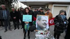 epa11878369 People attend a commemoration to mark the 12th anniversary of the opposition politician Chokri Belaid's assassination in front of his home in Tunis, Tunisia, 06 February 2025. The killing of the opposition leader with the left-secular Democratic Patriots' Movement Chokri Belaid outside his home on 06 February 2013 sparked a political crisis, which was deepened by the killing of another opposition figure, lawmaker Mohamed Brahmi, six months later. The sign reads 'Glory and immortality for the martyrs of the patris. Chokri Belaid'. EPA/MOHAMED MESSARA