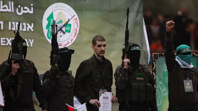 epa11882184 Palestinian fighters from Hamas's Izz ad-Din al-Qassam Brigades escort Israeli hostages Ohad Ben-Ami, Or Levi (pictured) and Eli Sharabi onto the stage before handing them over to a Red Cross team in Deir al-Balah, central Gaza, 08 February 2025. In exchange, Israel will release 183 Palestinian prisoners and detainees. EPA/HAITHAM IMAD