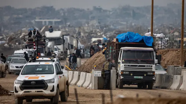 epa11886471 Egyptian soldiers observe Palestinians heading north from the southern Gaza Strip after Israeli forces withdrew from the Netzarim crossing, central Gaza Strip, 10 February 2025. EPA/HAITHAM IMAD