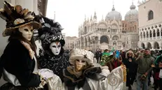 Tre personaggi, vestiti di costumi di fantasia, posano in piazza San Marco, per il carnevale veneziano, oggi 18 febbraio 2023. ANSA/ANDREA MEROLA