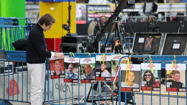 epa11881876 Portraits being attached to a barrier as people wait to watch a live stream on a big screen reporting on the release of the three Israeli hostages Eli Sharabi, Or Levy and Ohad Ben Ami, to be transferred from Hamas to the Red Cross, in hostages square outside the Kirya military base in Tel Aviv, Israel, 08 February 2025. Eli Sharabi, Or Levy and Ohad Ben Ami were taken hostage near the Israeli-Gaza border during the Hamas led October 7th attack. According to IDF around 76 hostages are still being held in Gaza. EPA/ABIR SULTAN