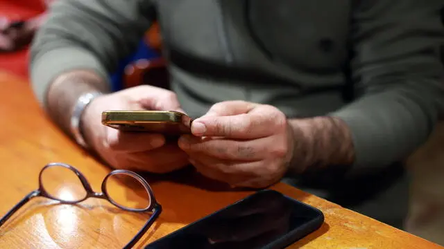 epa11796286 A man uses his smartphone while sitting in a cafe in Tehran, Iran, 28 December 2024. The Iranian government on 27 December 2024 unblocked Whatsapp and Google Play after two years, while the rest of the social media such as Telegram, Instagram, X and YouTube remain blocked. EPA/ABEDIN TAHERKENAREH