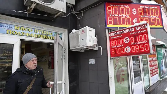 epa05113433 A man exits a shop past a board listing foreign currency rates against the Russian ruble in central Moscow, Russia, 20 January 2016. Russia's ruble currency fell to a record low versus the US dollar on 20 January as prices for the country's main export, oil, continued to tumble. The ruble slipped past the mark of 80.1 per US dollar in intraday trading, surpassing the previous record set in December 2014, according to a post on the Moscow Exchange bourse's website. Falling oil prices have the potential to jeopardize Russia's stability by severely weakening its economy. EPA/YURI KOCHETKOV