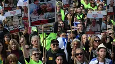 epa11882018 People watch a live stream on a big screen reporting on the release of the three Israeli hostages Eli Sharabi, Or Levy and Ohad Ben Ami, to be transferred from Hamas to the Red Cross, in hostages square outside the Kirya military base in Tel Aviv, Israel, 08 February 2025. Eli Sharabi, Or Levy and Ohad Ben Ami were taken hostage near the Israeli-Gaza border during the Hamas led October 7th attack. According to IDF around 76 hostages are still being held in Gaza. EPA/ABIR SULTAN