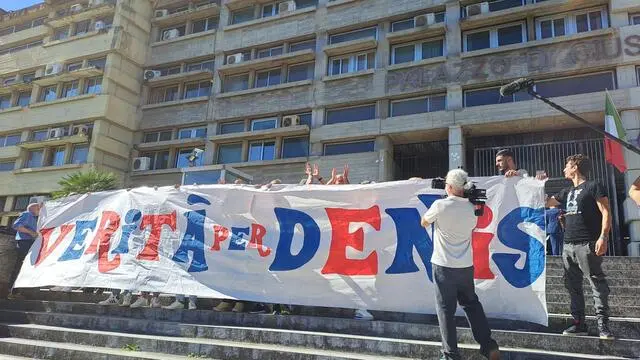 Striscioni rossoblu, un grande numero 8 - il suo numero di maglia - e cori in suo favore. I tifosi del Cosenza hanno voluto manifestare così, davanti al Tribunale di Cosenza, la loro vicinanza alla famiglia di Donato Denis Bergamini, 1 ottobre 2024. All'udienza, tra il pubblico anche gli ex compagni di squadra di Bergamini Michele Padovano, l'ex portiere Luigi Simoni e il centrocampista Alberto Urban, oltre a padre Fedele Bisceglia, storico tifoso del Cosenza. ANSA/SGHERRI