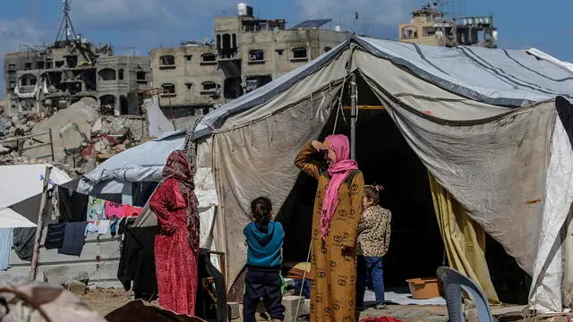 epa11893347 Palestinian women with children outside their shelters set up among the rubble of destroyed buildings amid a ceasefire between Israel and Hamas, in Jabalya, northern Gaza Strip, 13 February 2025. Israel and Hamas implemented the first phase of a hostage release and ceasefire deal on 19 January 2025. More than 46,000 Palestinians have been killed in the Gaza Strip, according to the Palestinian Ministry of Health, since Israel launched a military campaign in the strip in response to a cross-border attack led by the Palestinian militant group Hamas on 07 October 2023, in which about 1,200 Israelis were killed and more than 250 taken hostage. EPA/MOHAMMED SABER