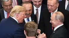 epa07681860 A handout photo made available by the G20 organizing host shows US President Donald J. Trump (2-L) shaking hands with Russian President Vladimir Putin (R) as Turkish Foreign Minister Mevlut Cavusoglu (3-L) and Turkish President Recep Tayyip Erdogan (2-R) stand by during the closing session of the G20 summit, in Osaka, Japan, 29 June 2019. The leaders of the world's largest economies gathered in Osaka for the fourteenth meeting of Group of Twenty (G20). EPA/G20 HANDOUT HANDOUT EDITORIAL USE ONLY/NO SALES