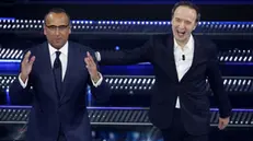 Sanremo Festival host and artistic director Carlo Conti (L) and Italian actor Roberto Benigni on stage at the Ariston theatre during the 75th edition of the Sanremo Italian Song Festival, in Sanremo, Italy, 14 February 2025. The music festival will run from 11 to 15 February 2025. ANSA/FABIO FRUSTACI