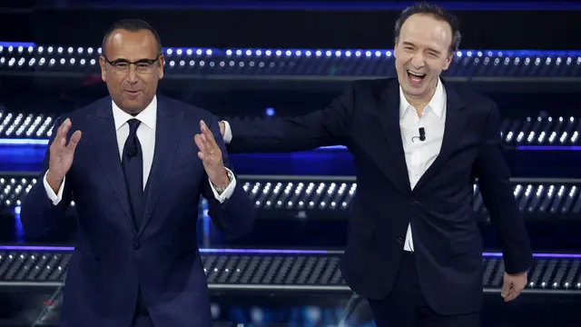 Sanremo Festival host and artistic director Carlo Conti (L) and Italian actor Roberto Benigni on stage at the Ariston theatre during the 75th edition of the Sanremo Italian Song Festival, in Sanremo, Italy, 14 February 2025. The music festival will run from 11 to 15 February 2025. ANSA/FABIO FRUSTACI