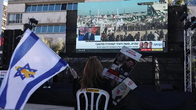 epa11897246 A woman watches a live stream reporting on the release of three Israeli hostages, outside the Kirya military base in Tel Aviv, Israel, 15 February 2025. Hamas confirmed the three hostages to be Alexander Troufanov, Yair Horn and Sagui Dekel-Chen, who were taken from Kibbutz Nir Oz during the 07 October 2023 attack. Israel and Hamas implemented the first phase of a hostage release and ceasefire deal on 19 January 2025. EPA/ATEF SAFADI