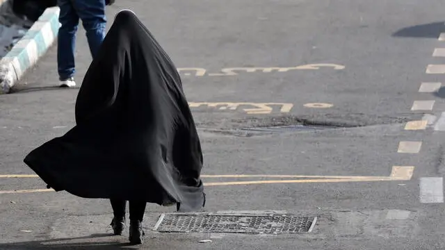 epa11605787 A veiled Iranian woman walks in a street in Tehran, Iran, 15 September 2024, on the second anniversary of protests following Mahsa Amini's death. Mahsa Amini, a 22-year-old Iranian woman, was arrested in Tehran on 13 September 2022 by the police unit responsible for enforcing Iran's strict dress code for women. She fell into a coma while in police custody and was declared dead on 16 September 2022. Her death led to anti-government protests worldwide. EPA/ABEDIN TAHERKENAREH