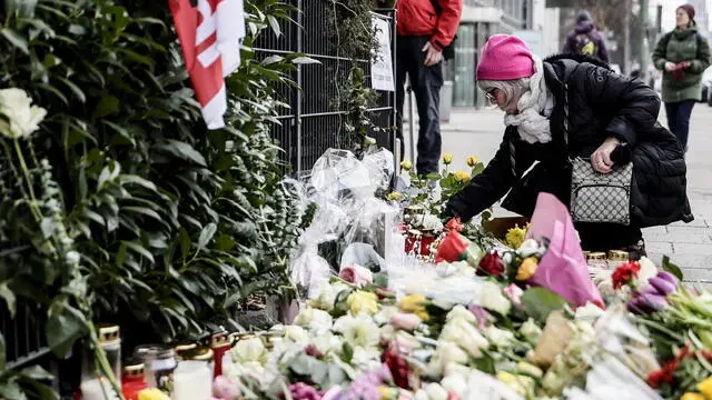 epa11898616 A woman lays a flower at the mourning site after a car rammed into a rally in Munich, Germany, 15 February 2025. According to Munich police, at least 36 people were injured when a car drove into a crowd of demonstrators during a rally by the Verdi trade union in Munich's city center on 13 February. EPA/RONALD WITTEK