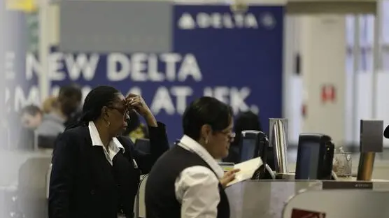 epa04009222 A Delta airlines ticket employee (L) holds her head while looking at outgoing flights out of JFK Airport, New York, USA, 05 January 2014. A Delta Connection 4100 plane carrying 35 people left Toronto this morning and skidded off of runway 22L and into a snowbank at JFK airport. No injuries we're reported. The airport reopened at 11:30 am. EPA/JASON SZENES