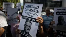 epa11667591 A person holds a sign with the image of a detainee that reads 'Americo de Grazia seized by the dictartorship' during a demonstration in front of the headquarters of the Penitentiary Service Ministry, in Caracas, Venezuela, 18 October 2024. Relatives of those considered political prisoners in Venezuela protested in front of the headquarters of the Ministry of Penitentiary Service, in Caracas, to demand a 'dignified treatment' of confinement, as they allege the conditions of confinement are 'deplorable' due to, among other things, poor quality food. EPA/MIGUEL GUTIERREZ