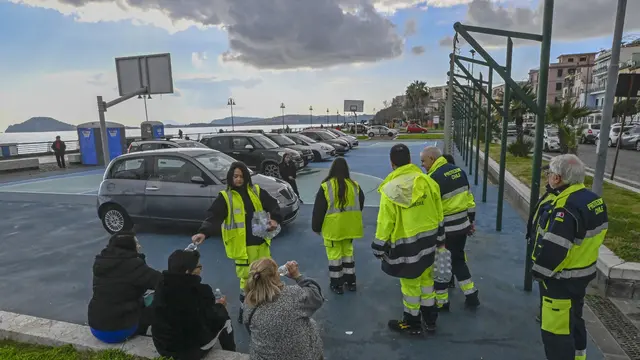 Operatori della Protezione civile distribuiscono acqua sul lungomare Pertini di Pozzuoli dove ci sono le auto parcheggiate di famigie che a causa dello sciame sismico hanno deciso di lasciare e abitazioni 17 febbraio 2025 ANSA / CIRO FUSCO