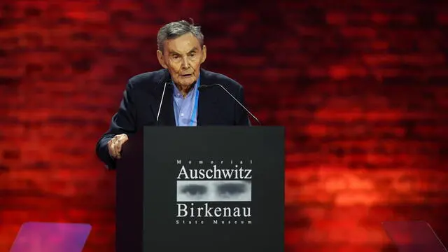 epa11856826 Holocaust survivor Marian Turski delivers a speech at a ceremony commemorating the 80th anniversary of liberation of the former German Nazi concentration and extermination camp KL Auschwitz-Birkenau in front of the historic gate of the former KL Auschwitz II-Birkenau in Brzezinka, Poland, 27 January 2025. The largest German Nazi extermination camp, KL Auschwitz-Birkenau, was liberated by the Red Army on 27 January, 1945. The world commemorates its liberation every year on January 27 as International Holocaust Remembrance Day. EPA/LUKASZ GAGULSKI POLAND OUT