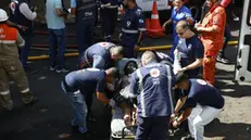 epa11890902 A person is treated by medical staff after a fire in a textile factory in Rio de Janeiro, Brazil, 12 February 2025. The fire broke out in the textile factory specializing in carnival costumes. EPA/Antonio Lacerda