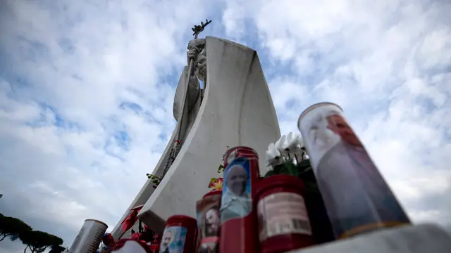 Candele sotto la statua di Giovanni Paolo II allingresso dell’Ospedale Policlinico Gemelli, dove è ricoverato Papa Francesco, Roma, 20 febbraio 2025. ANSA/ANGELO CARCONI