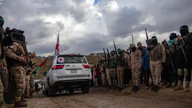 epa11909303 Palestinian civilians and fighters from Hamas's Izz ad-Din al-Qassam Brigades attend the handover of the bodies of four Israeli hostages to the Red Cross, in Khan Yunis, southern Gaza Strip, Thursday, 20 February, 2025. Hamas was set to hand over the bodies of four Israeli captives, including that of youngest hostage Kfir Bibas, as part of the ongoing Gaza ceasefire deal. Hamas said in November 2023 that the two Bibas boys and their mother had been killed in an Israeli airstrike on Gaza. EPA/HAITHAM IMAD